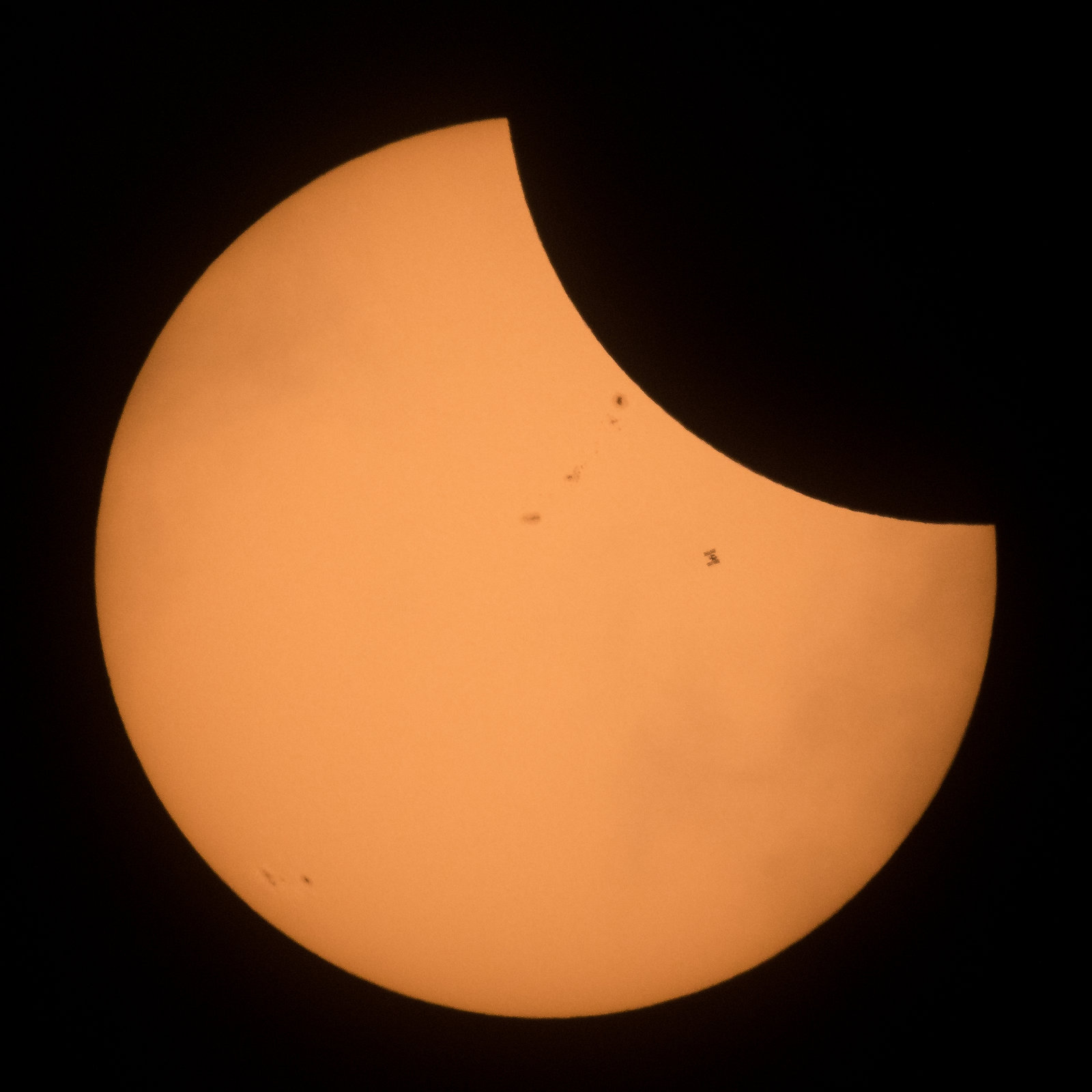ISS in front of the partially eclipsed Sun